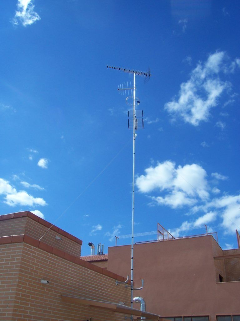 Una antena alta en la parte superior de un edificio con un cielo azul de fondo.