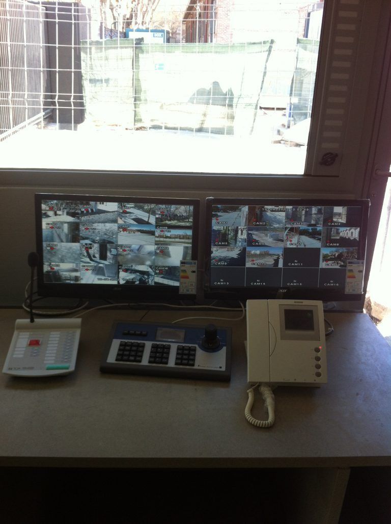 Un escritorio con dos monitores y un teléfono encima.